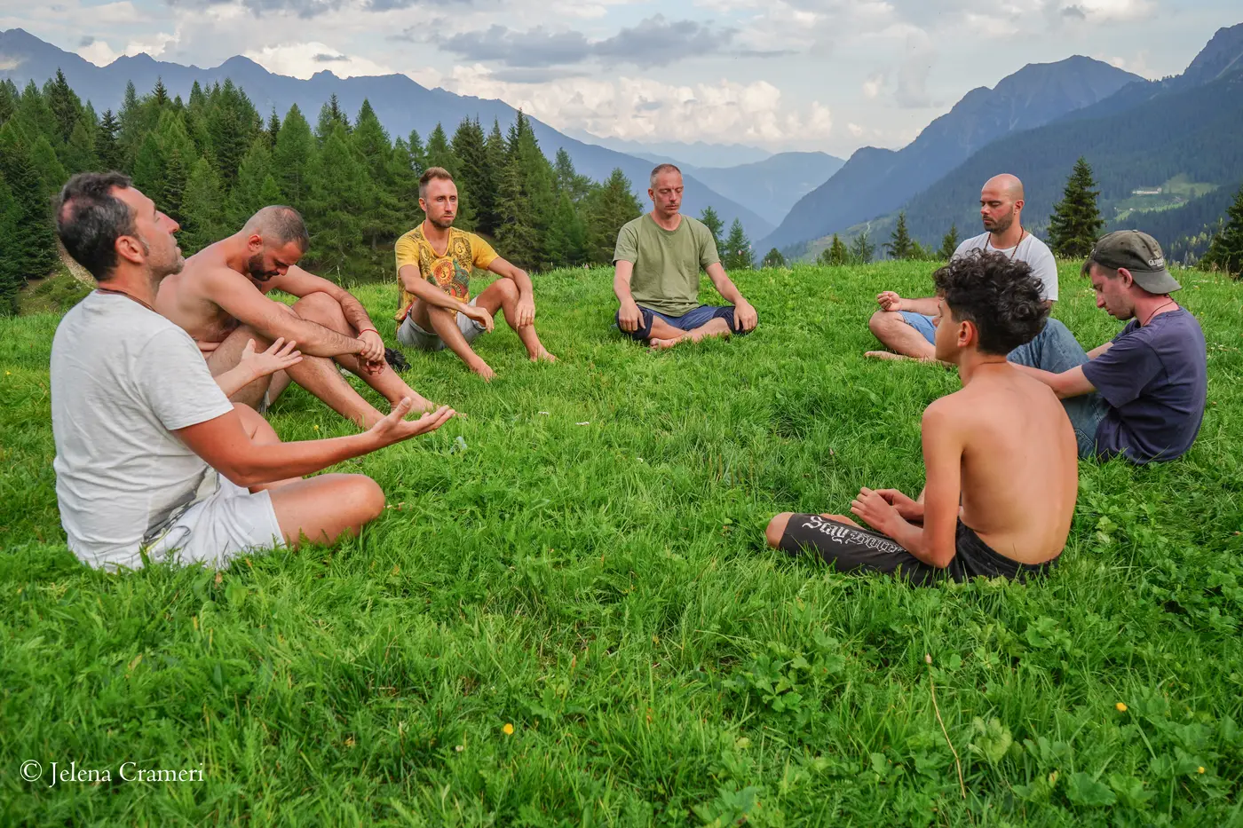 Cerchio maschile in meditazione sul prato alpino di Alpe Ur, Val Poschiavo