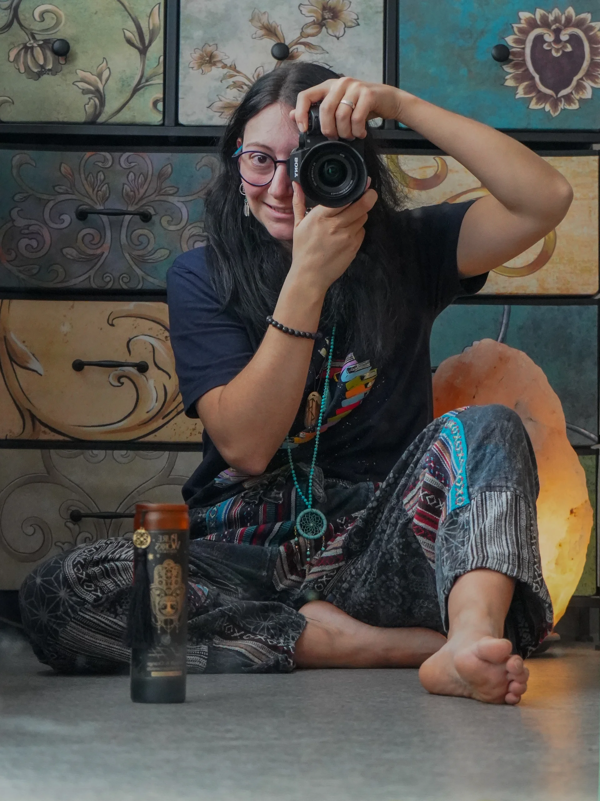 Jelena Crameri, fotografa olistica, accovacciata con la sua macchina fotografica