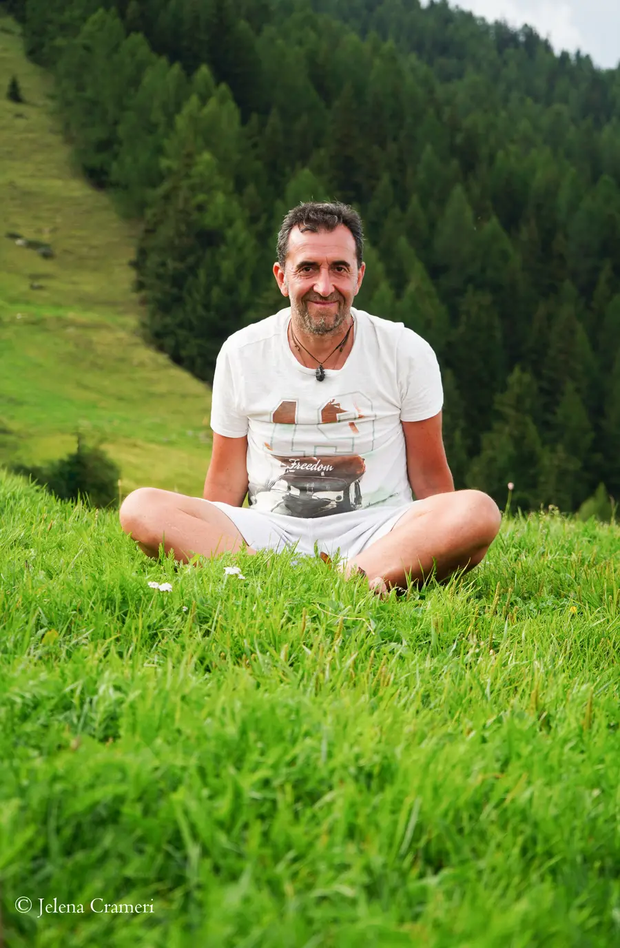 Uomo sorridente in meditazione con vista sulla valle